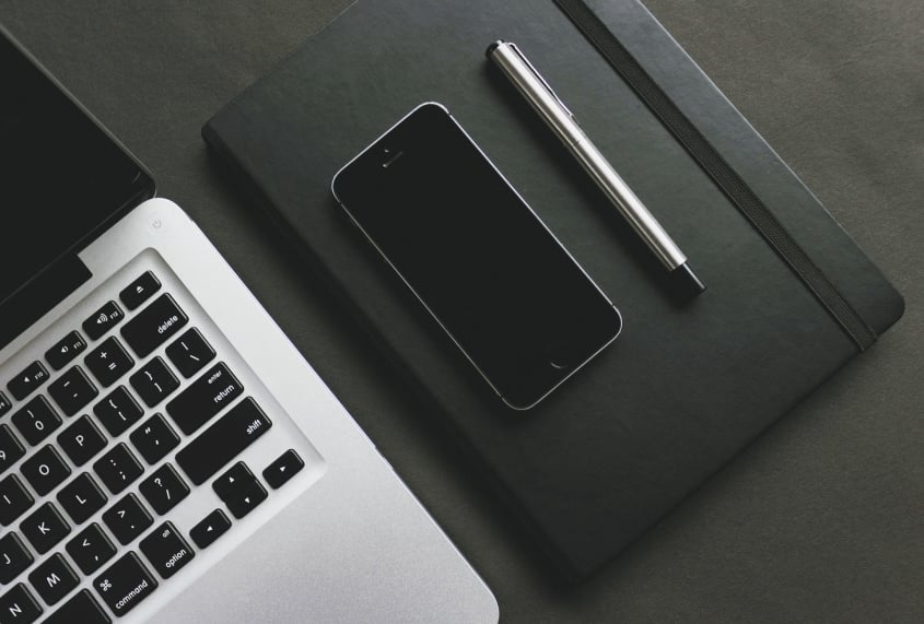 laptop phone notebook and pen